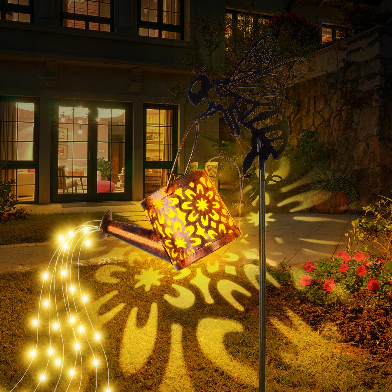Decorative metal art piece casting a pattern on the ground with string lights in a garden setting.